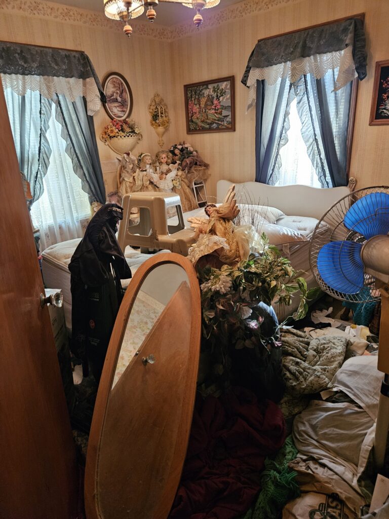 Professional hoarding junk removal team clearing a heavily cluttered living room in Cleveland.