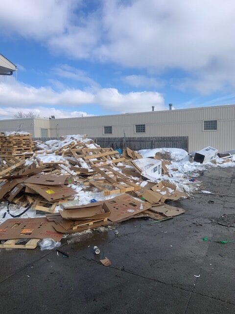 A large pile of wood scraps, drywall, and construction debris from a renovation project, ready for removal.