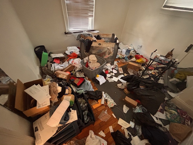 Professional hoarding junk removal service in Cleveland, Ohio, featuring a team clearing a heavily cluttered room.